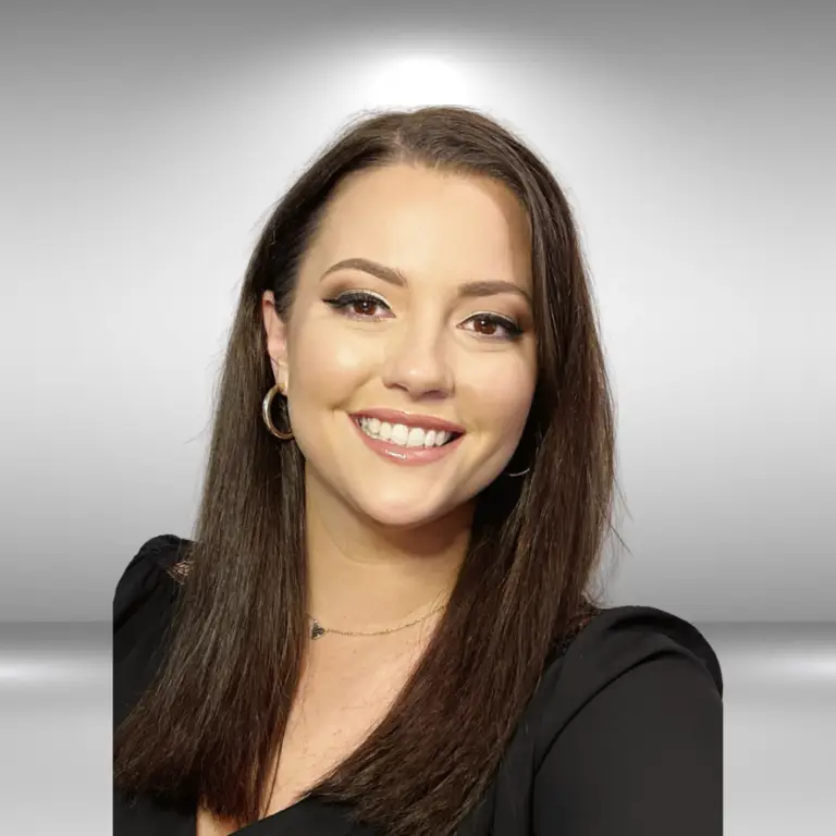 A woman with shoulder-length brown hair is smiling at the camera. She is wearing a black top, hoop earrings, and a delicate necklace. The softly lit gradient background, accentuated by a subtle light halo effect behind her head, highlights her as an emerging talent in the influencer space.