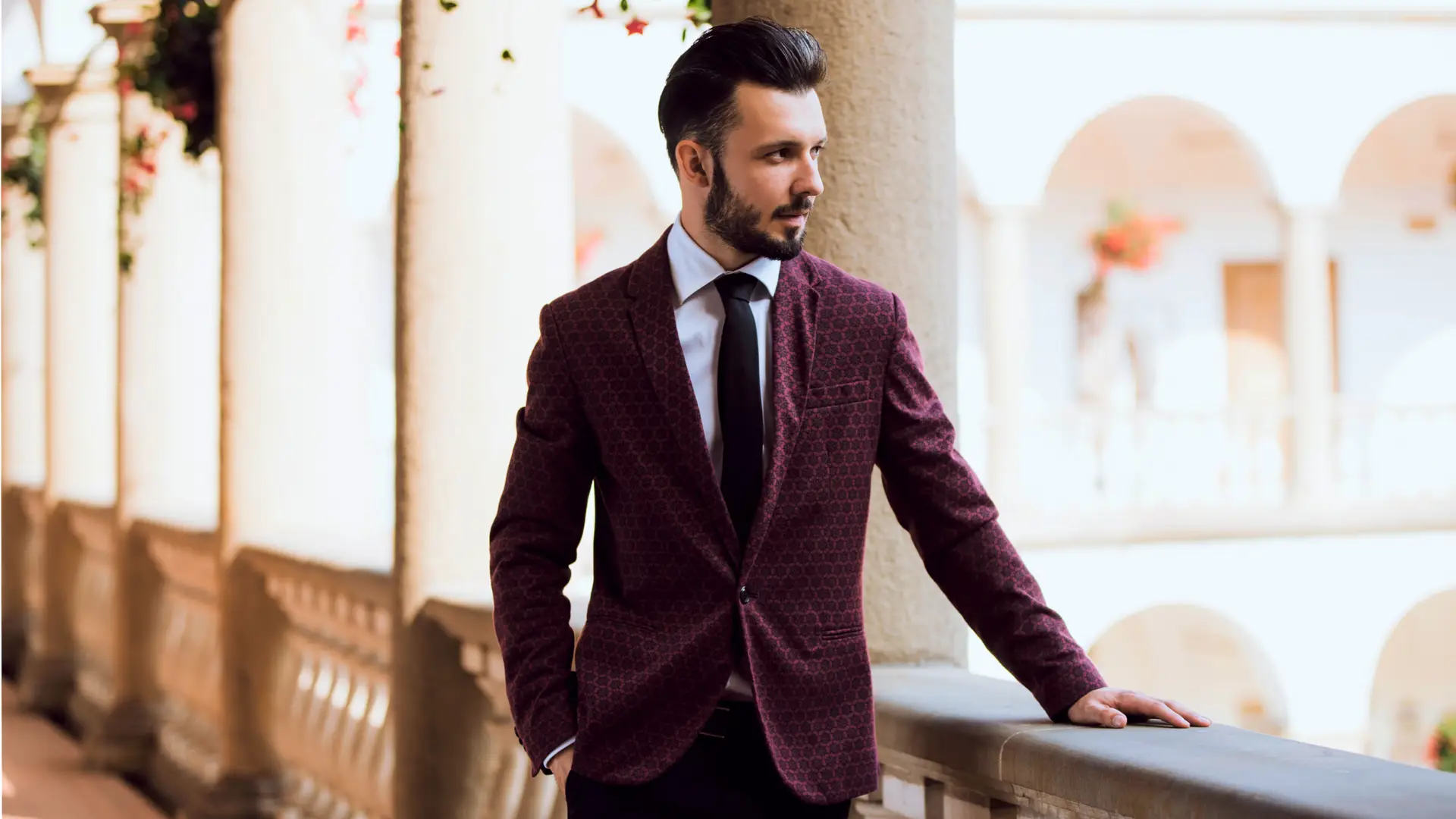 male model in a suit leaning with hand on railing