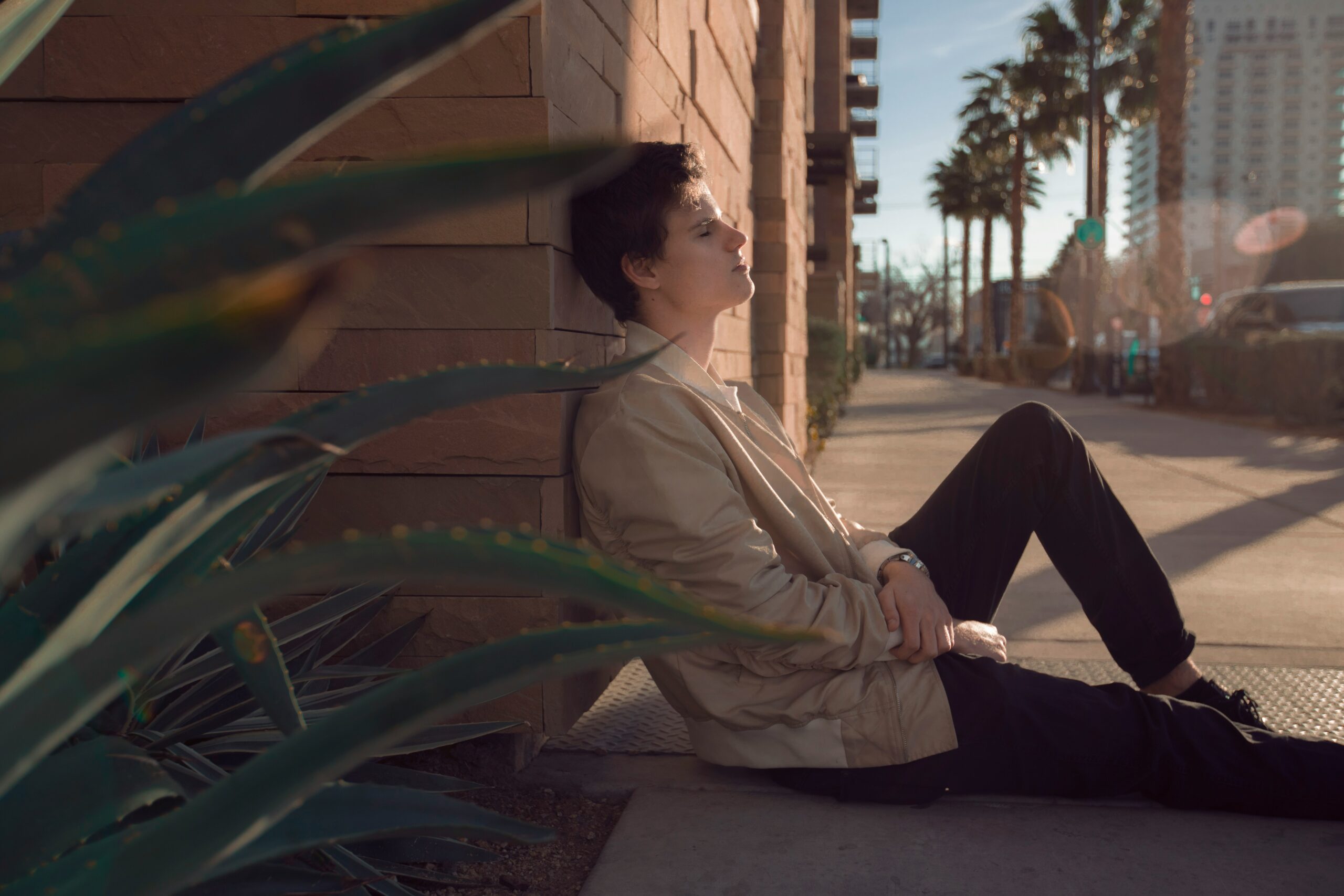 casual male model sitting on the ground